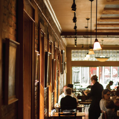 Guests dining beside the tall windows in Grapevine Cafe's historic dining room